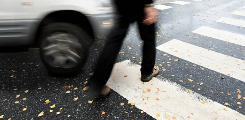pedestrian walking at a crosswalk as a car approaches